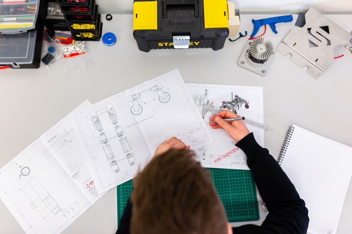 Engineer marking up fabrication drawings at a workbench