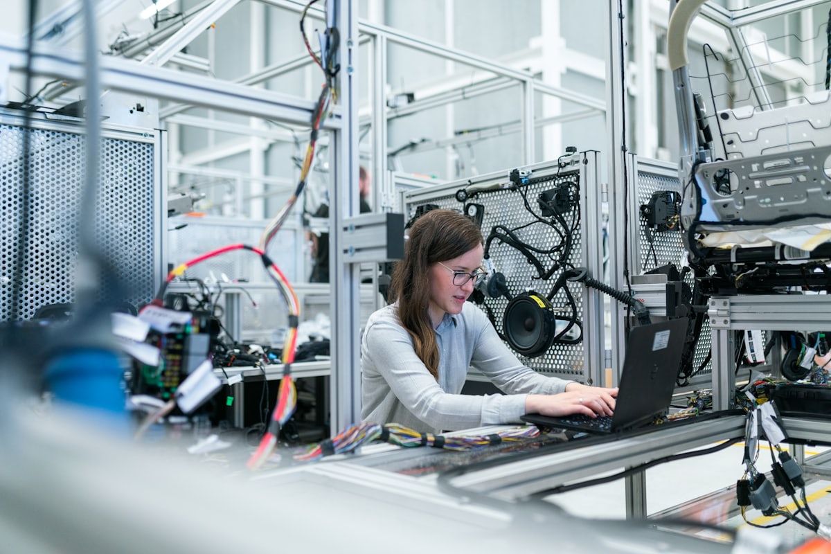 Engineer monitoring a connected production line from a laptop